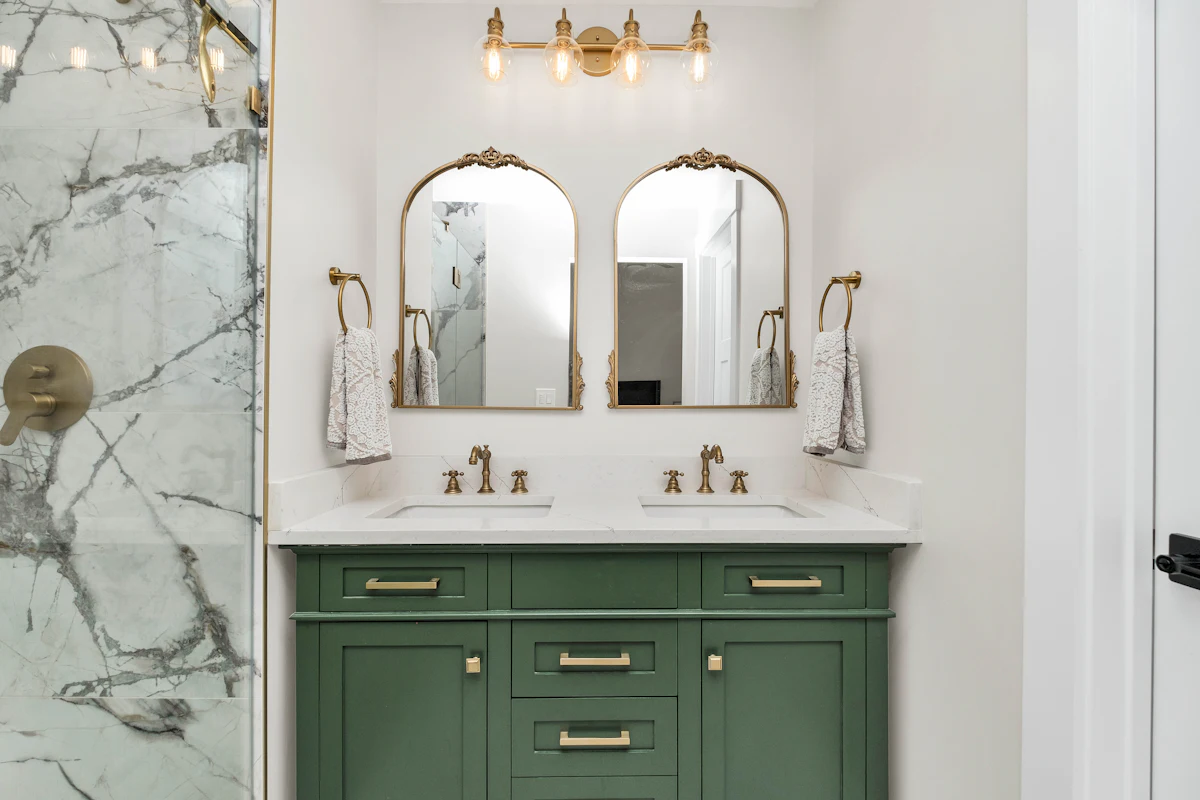 Bathroom with marble counters and green cabinets